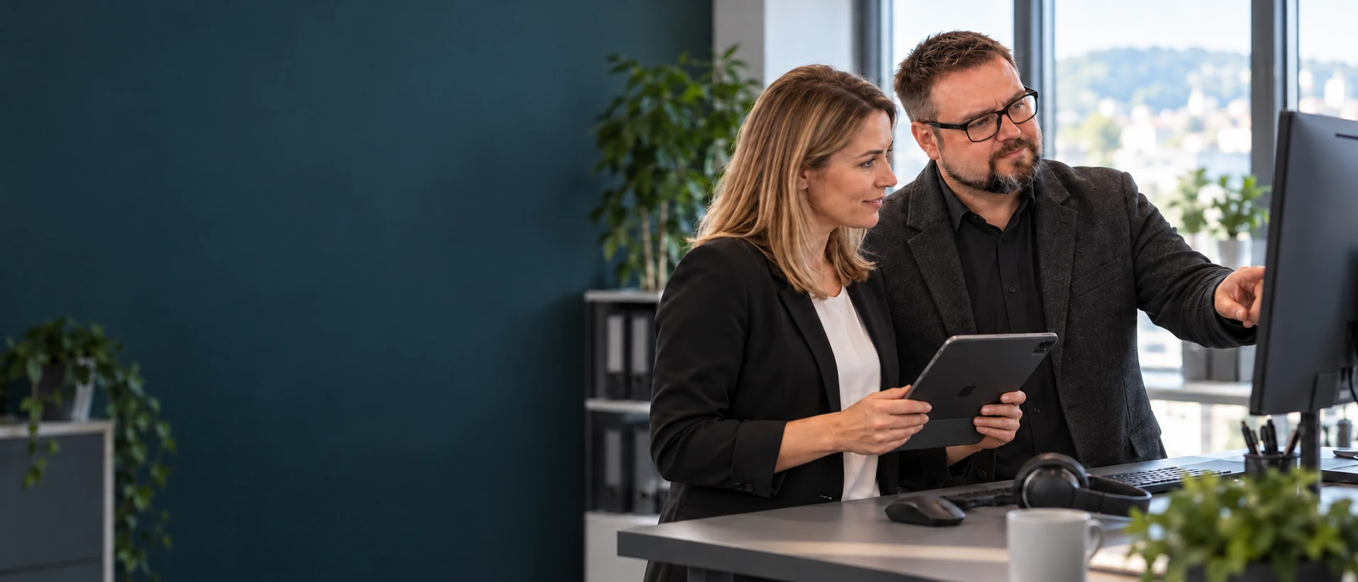 Herbert Röblreiter und eine Ansprechpartnerin prüfen einen Arbeitsplatz mit einer Checkliste auf dem iPad.